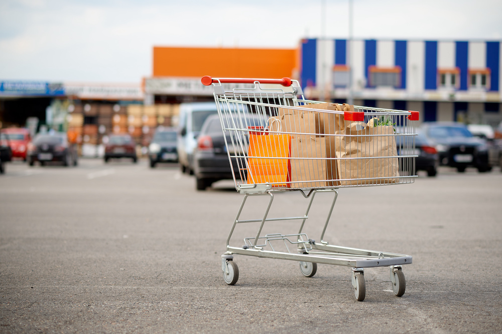 abandoned cart in parking lot with bags